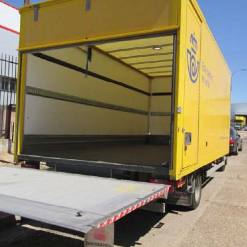 Camión amarillo de nuestra flota para el servicio de Correos con la puerta de carga abierta