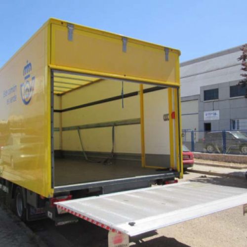 Camión amarillo de nuestra flota para el servicio de Correos con la puerta de carga abierta